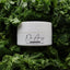 White jar of Dr. Angs cream surrounded by green leafy vegetables