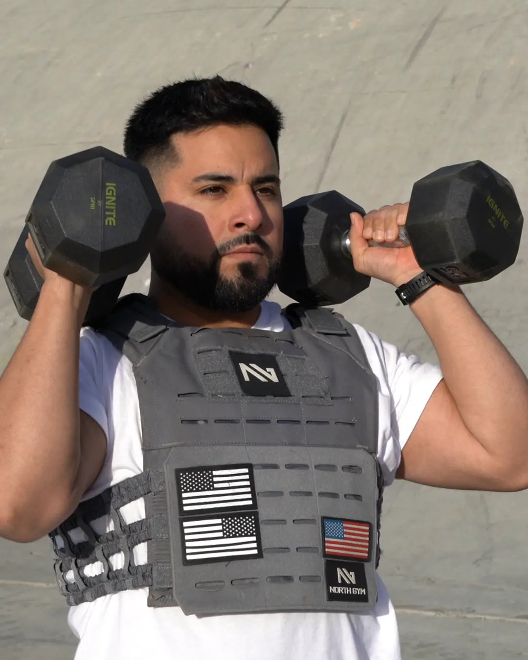Man training outdoors with dumbbells and a weight vest