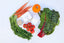Dr. Arsy skincare product for sensitive & eczema-prone skin hydration barrier repair. Assorted fresh vegetables, including carrots, tomatoes, and greens, on a white background