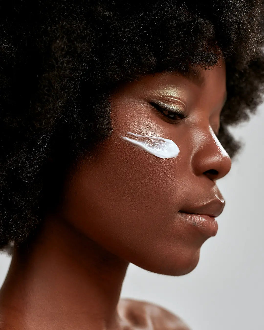 Woman with a swipe of moisturizer on her cheek