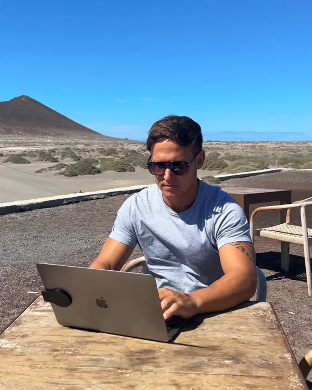 Man working on a laptop outdoors in the sun